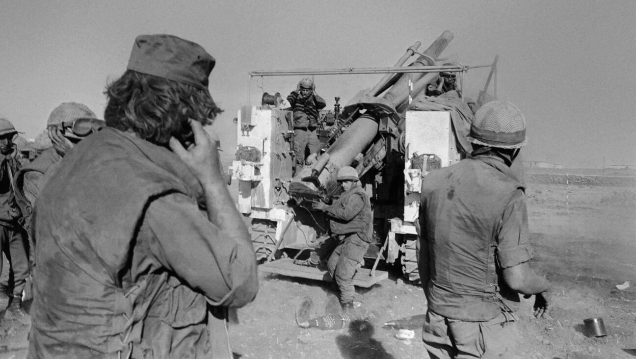 Israeli soldiers plug their ears as they fire shells at the Syrian lines on the Syrian Golan Heights, almost two weeks after the beginning of the Yom Kippur War, on Oct. 17, 1973. 