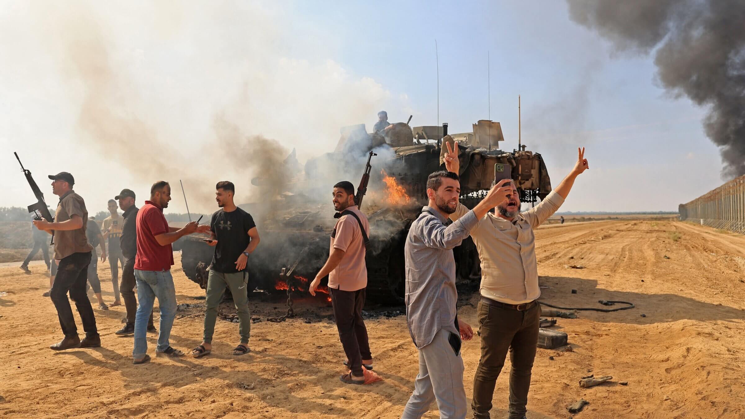 Palestinians take control of an Israeli tank after crossing the border fence with Israel from Khan Yunis in the southern Gaza Strip on Oct. 7, 2023.