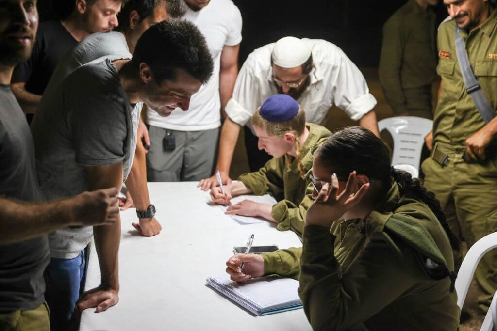 Reserve Israeli soldiers line up to register for duty in a northern Israeli town on October 7, 2023, after Palestinian militant group Hamas launched a large-scale surprise attack against Israel.