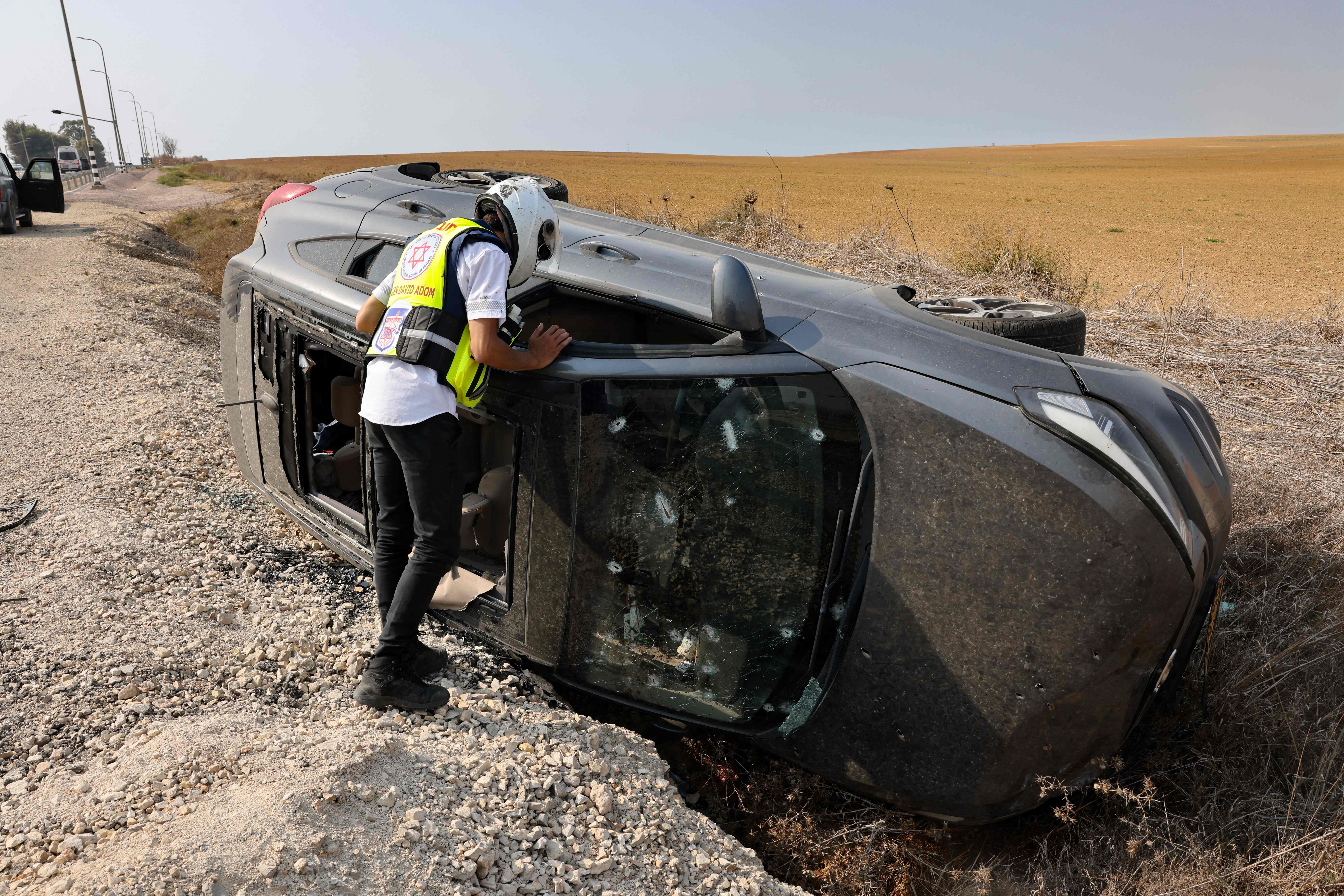 A member of Magen David Adom emergency medical services checks a car near the southern Israeli city of Sderot that was shot at during the Oct. 7 attacks by Hamas. Millions of dollars in donations from U.S. corporations and philanthropies are going to humanitarian organizations like Magen David Adom. 