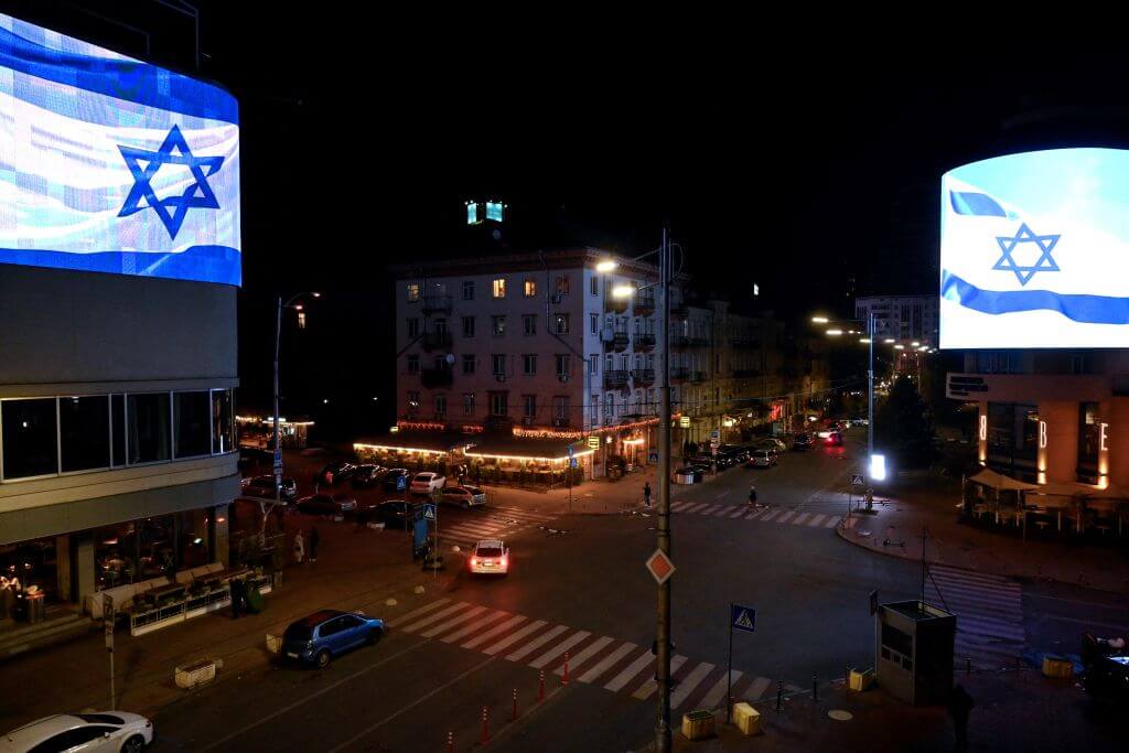 Israeli national flags are seen on giant screens on a street in the Ukrainian capital Kyiv on October 8, 2023.