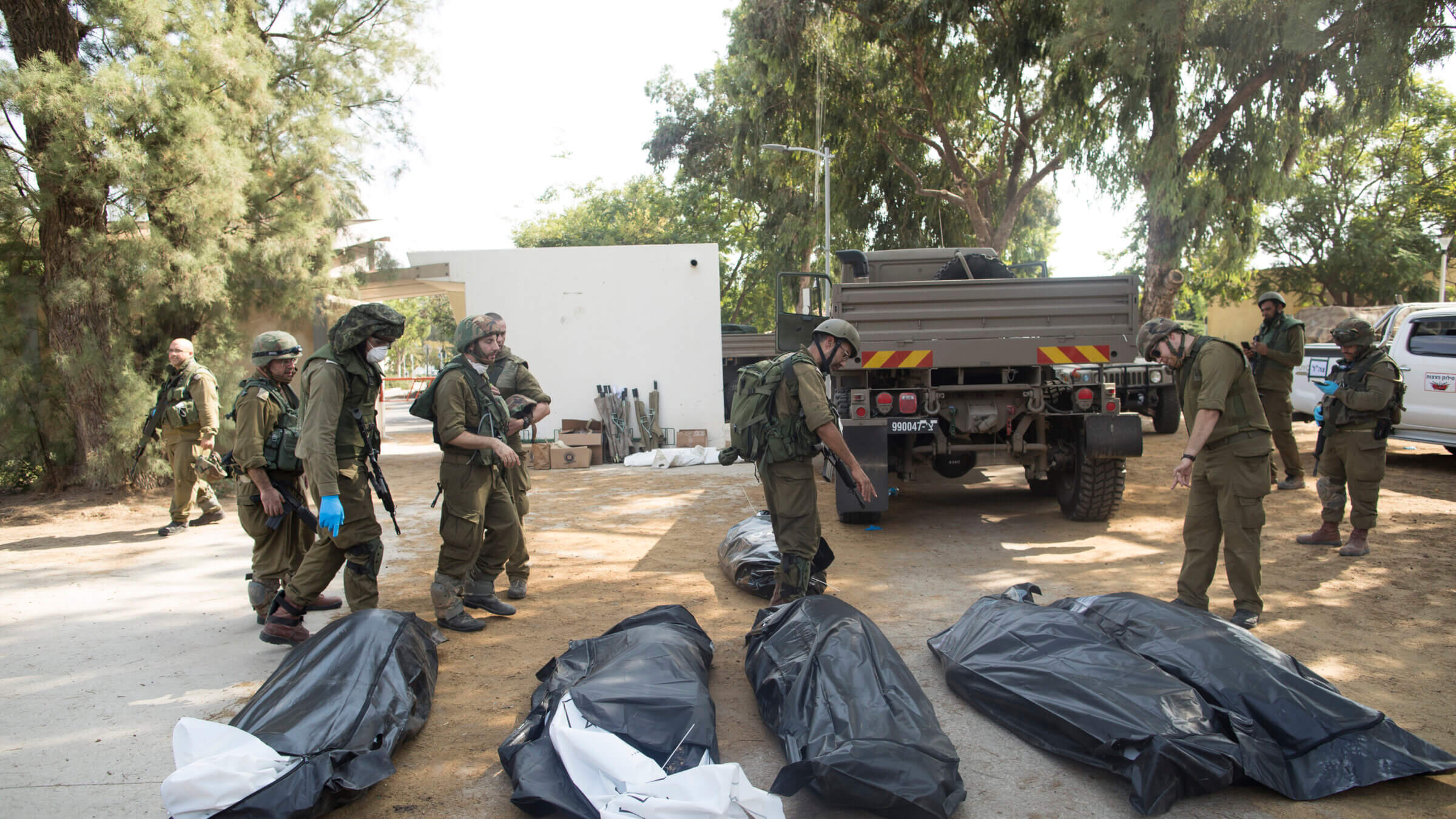 Israeli soldiers remove the bodies of civilians, who were killed days earlier in an attack by Palestinian militants on this kibbutz near the border with Gaza on Tuesday.