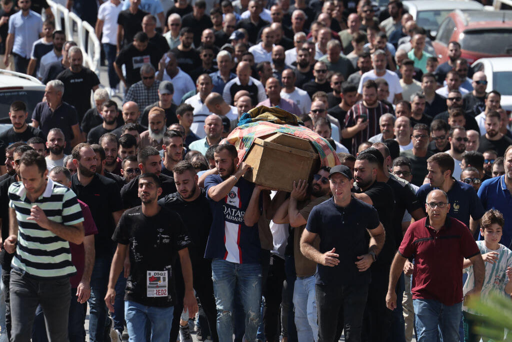 Mourners carry the coffin on Majed Ibrahim, who died as a result of wounds sustained after a rocket attack in the Arab-Israeli town on October 9, during his funeral in the Arab-Israeli town of Abu Ghosh, near Jerusalem on October 14, 2023