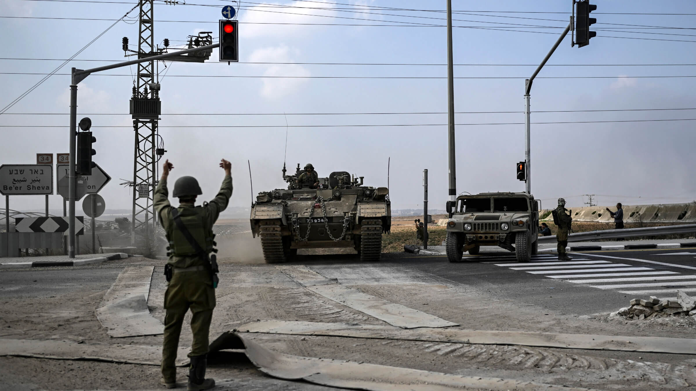 An Israeli army soldier directs an approaching Puma armored personnel carrier moving near the Gaza border in southern Israel on Oct. 14, 2023.