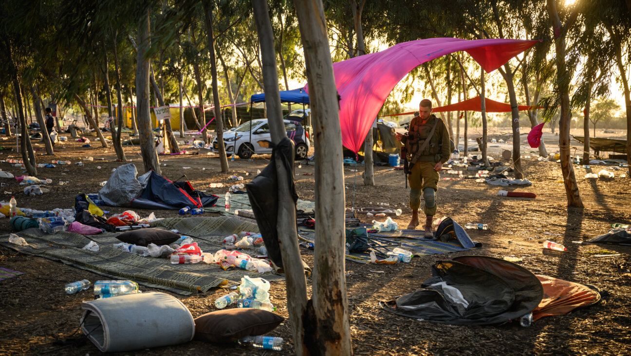 Members of Israeli security forces search for identification and personal effects at the Tribe of Nova music festival site, where 364 people were killed and dozens taken by Hamas militants.