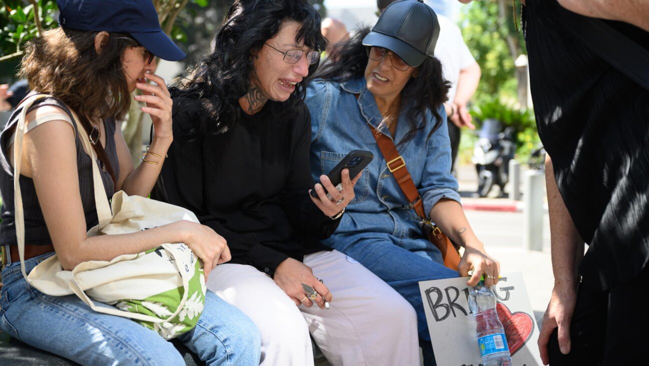 TEL AVIV: Friends comfort Osa Me'ir (center) Friday after she learned that the second of her twin brothers was confirmed killed during the Hamas attack. (Leon Neal/Getty Images)