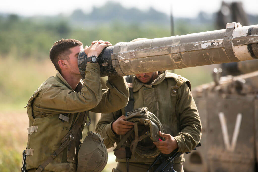 An Israeli soldier looks into a barrel of a tank on the Israeli border with the Gaza Strip on October 19, 2023 in Sderot, Israel. 