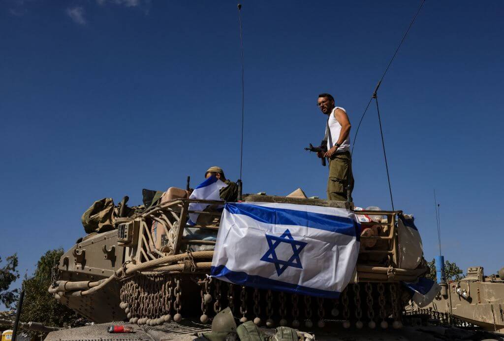An Israeli soldier stands on top of a Merkava tank near the border with the Gaza Strip on Oct. 20, 2023.