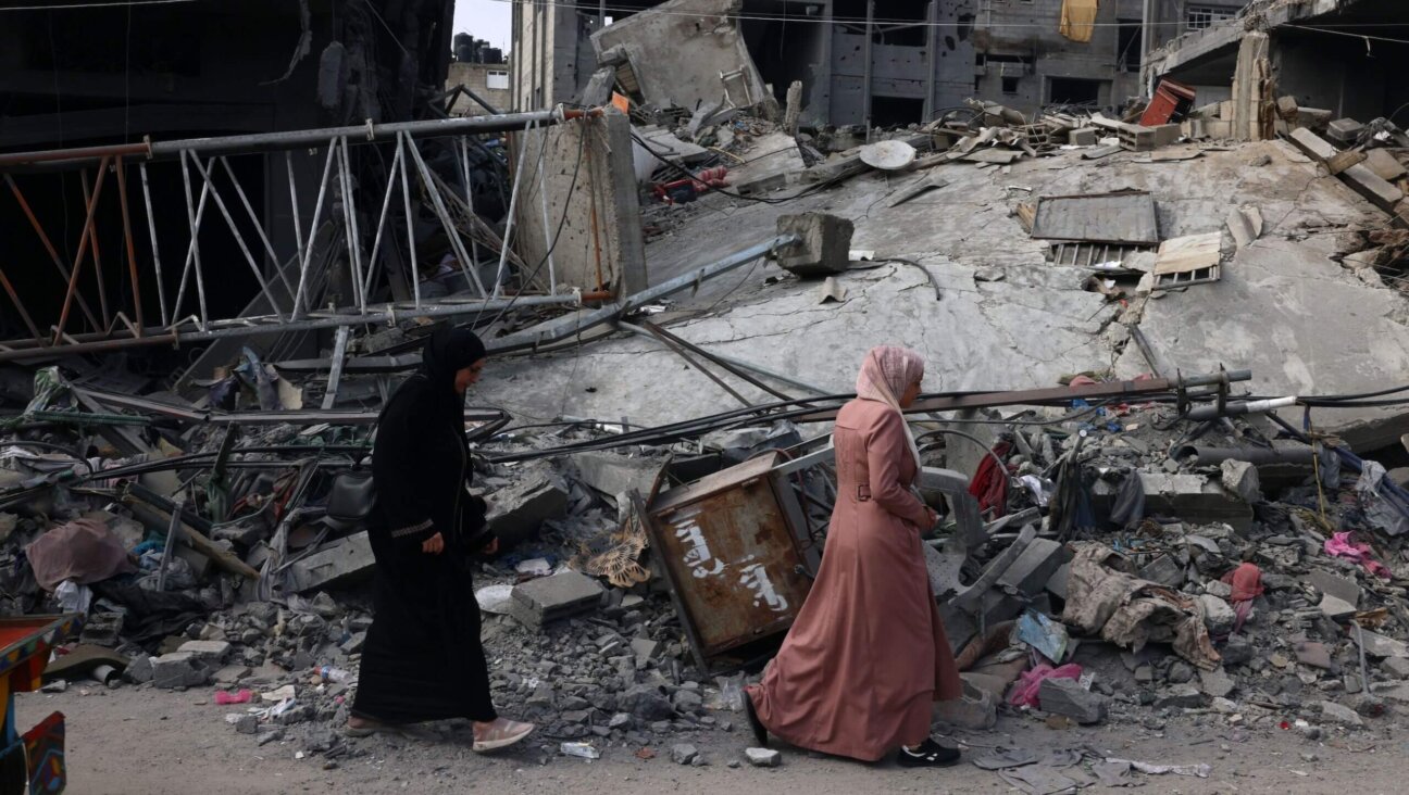 Women walk past a destroyed building in the aftermath of Israeli bombing in Rafah in the southern Gaza Strip on Saturday.