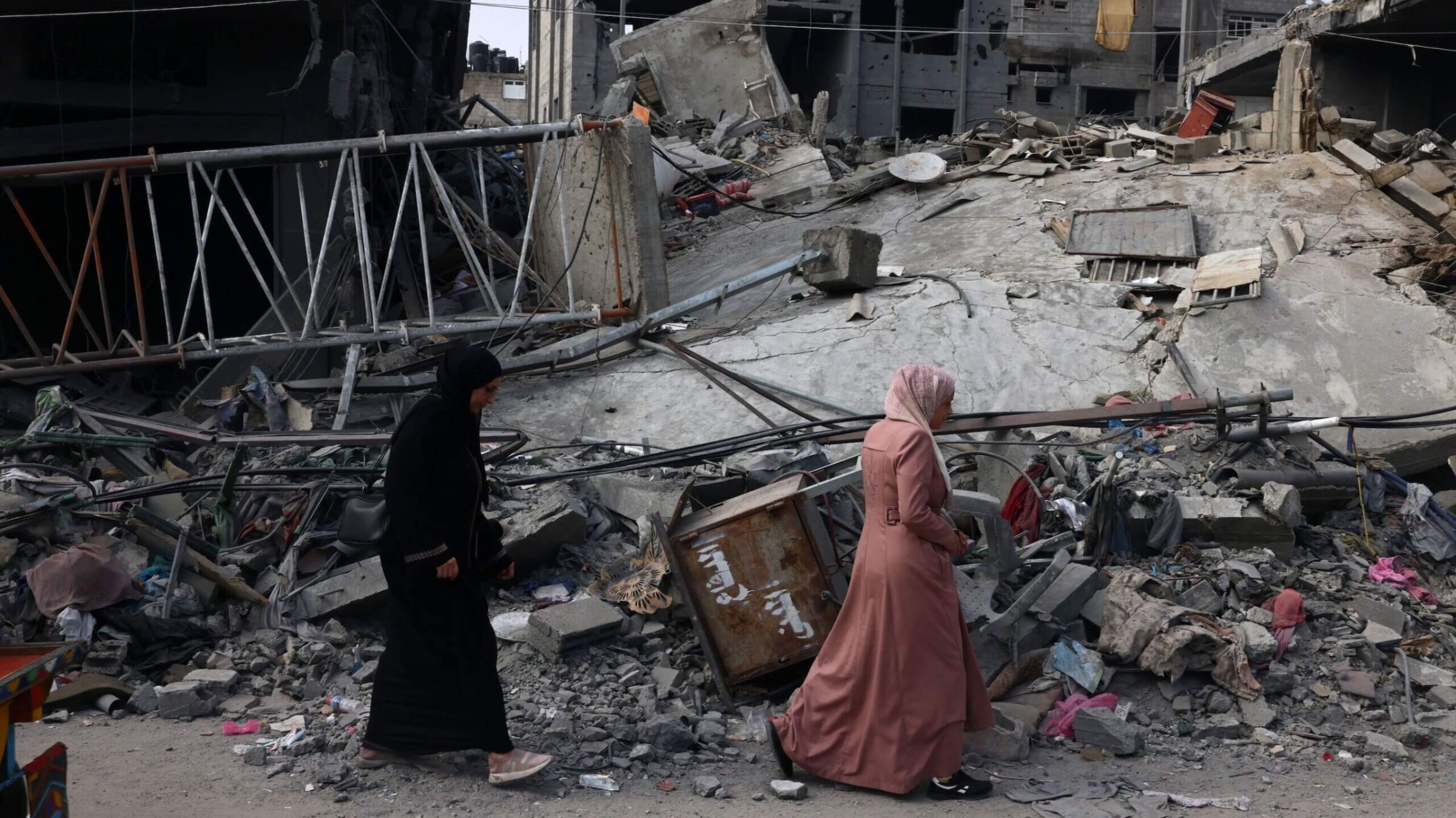 Women walk past a destroyed building in the aftermath of Israeli bombing in Rafah in the southern Gaza Strip on Saturday.