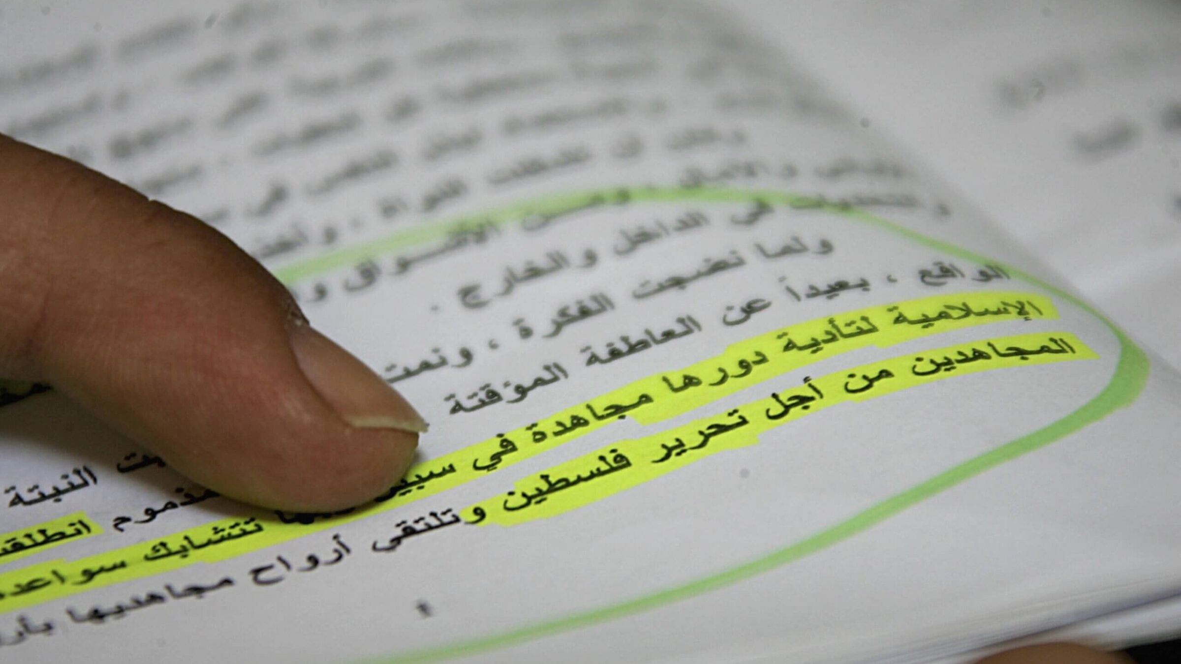 A Palestinian member of Hamas holds an Arabic copy of its charter in 2006. The highlighted sentence reads "When our enemies usurp some Islamic lands, Jihad becomes a duty binding on all Muslims. In order to face the usurping of Palestine by the Jews, we have no escape from raising the banner of Jihad." 