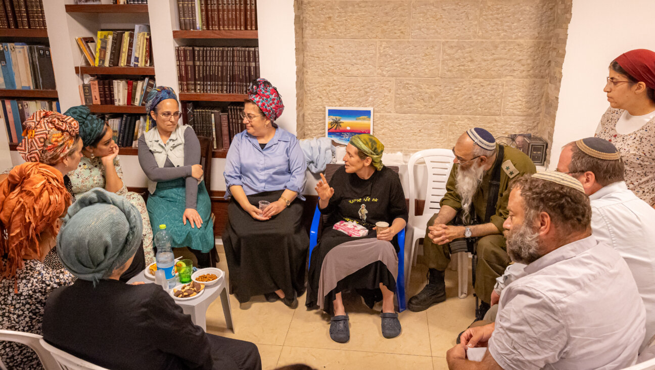 Residents of Mitzpe Yericho gather in the home of Rabbi Achiya and Idit Eliyahu (in the green headscarf), who are sitting shiva following the death of their 19 year-old son, Ariel.