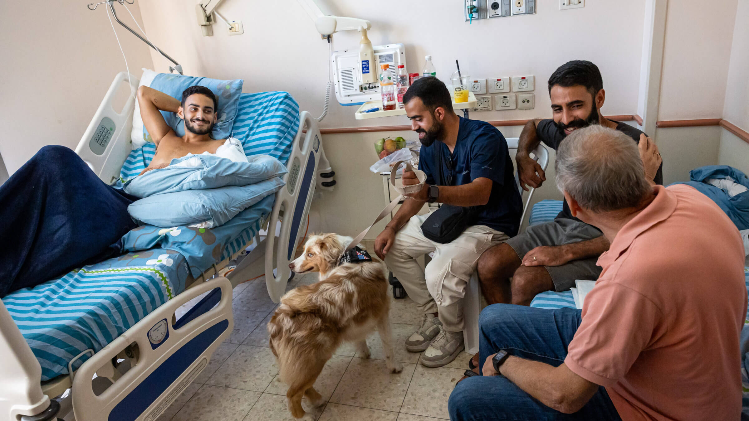 A 19-year-old wounded IDF soldier, <i>left</i>, meets with volunteers from BeLev Echad and their therapy dog, Damka, at Bellingson Hospital in Petah Tikva, Israel, on Oct. 11, 2023.