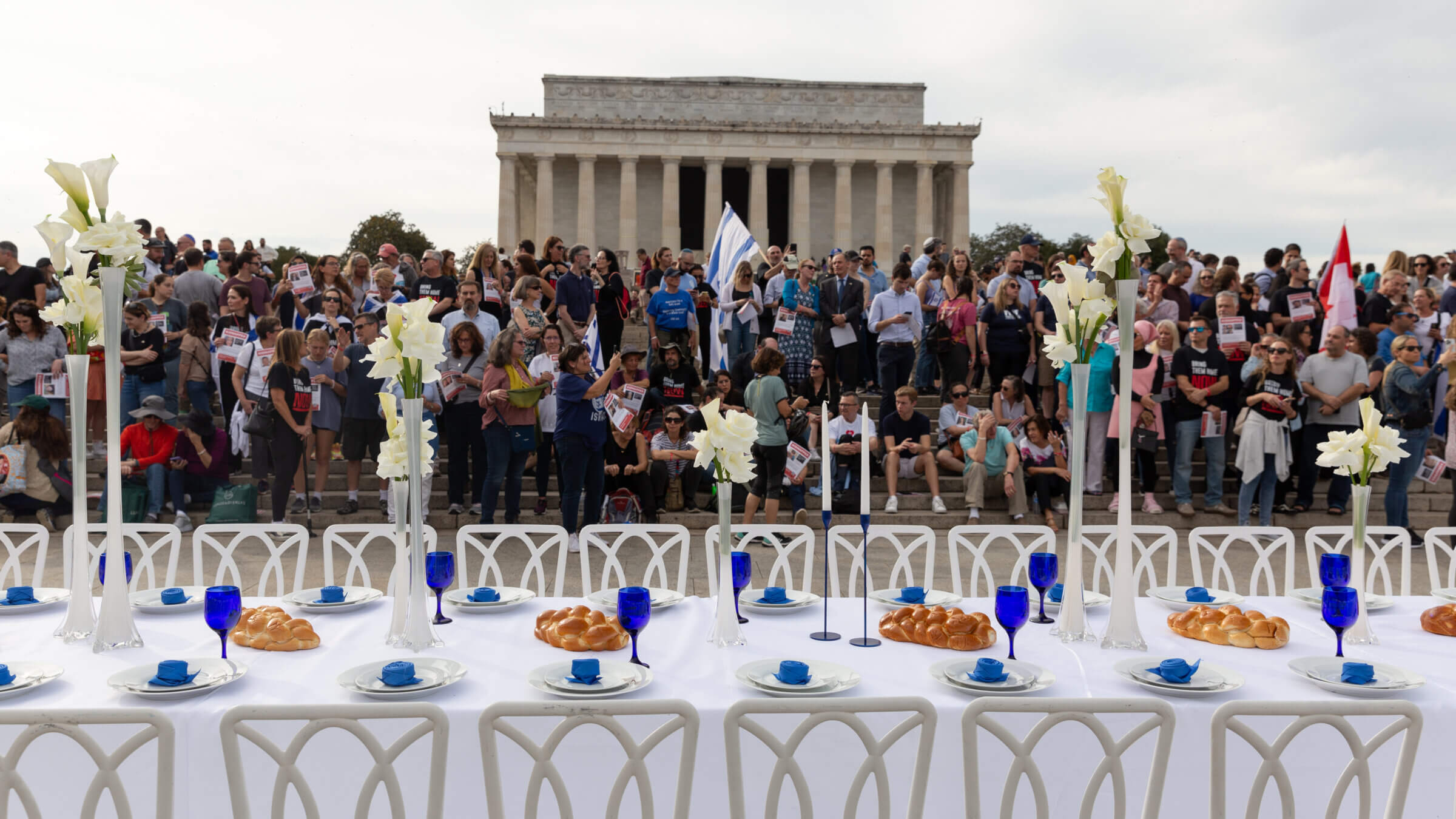 People gather on the steps of the Lincoln Memorial in front of a Shabbat table set for the hostages being held in Gaza. The Jewish community has poured significant energy into freeing the hostages, although some experts say these efforts don't always have a strategic focus.