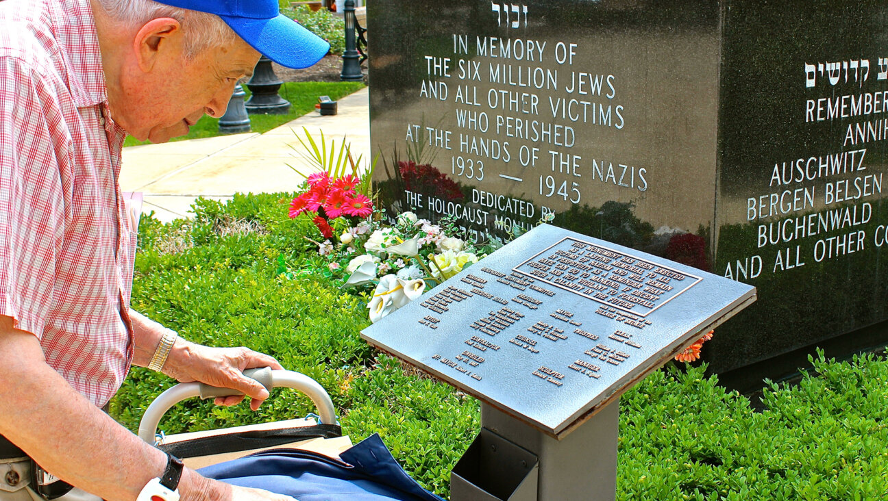 Holocaust survivor Larry Heimlich reads a plaque at the Holocaust Monument in Skokie, Illinois, in 2014.