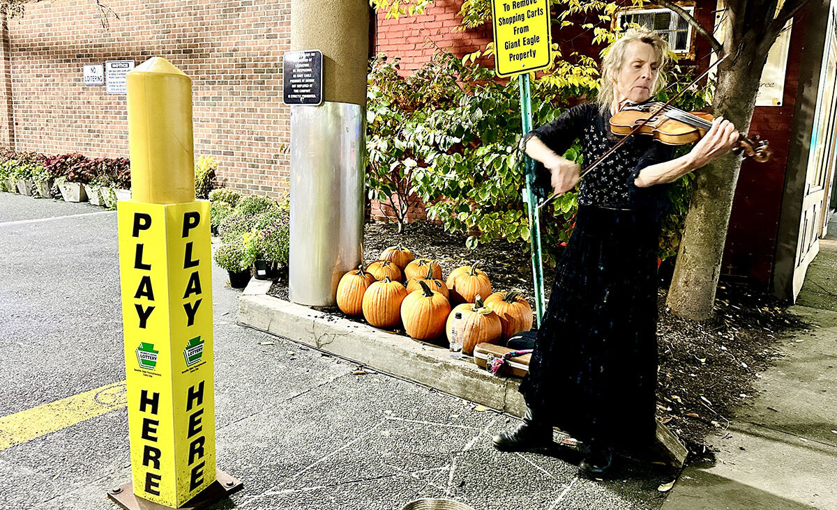 Kimberly Faught, known as the Gypsy Violin Queen of Squirrel Hill, performs in front a Giant Eagle supermarket in Pittsburgh.