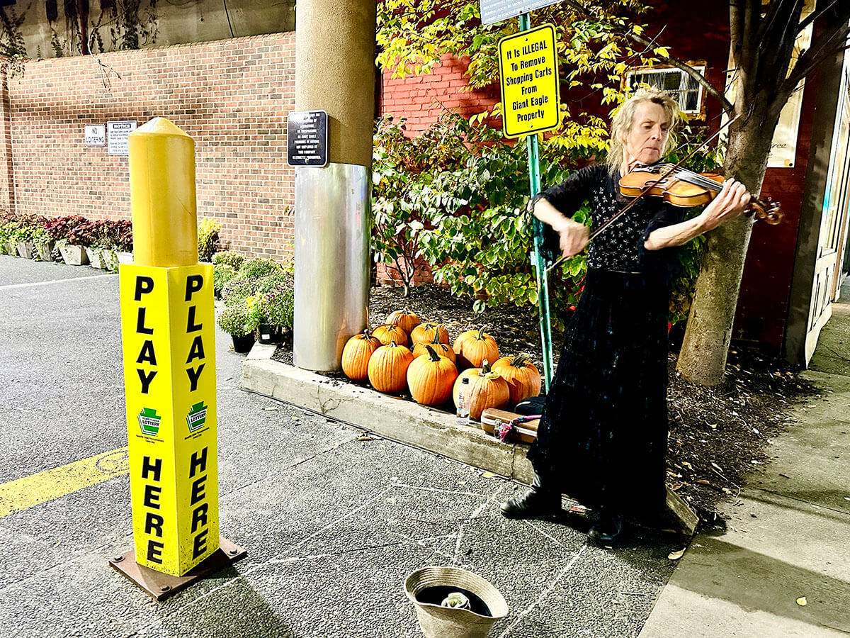 Kimberly Faught, known as the Gypsy Violin Queen of Squirrel Hill, performs in front a Giant Eagle supermarket in Pittsburgh.