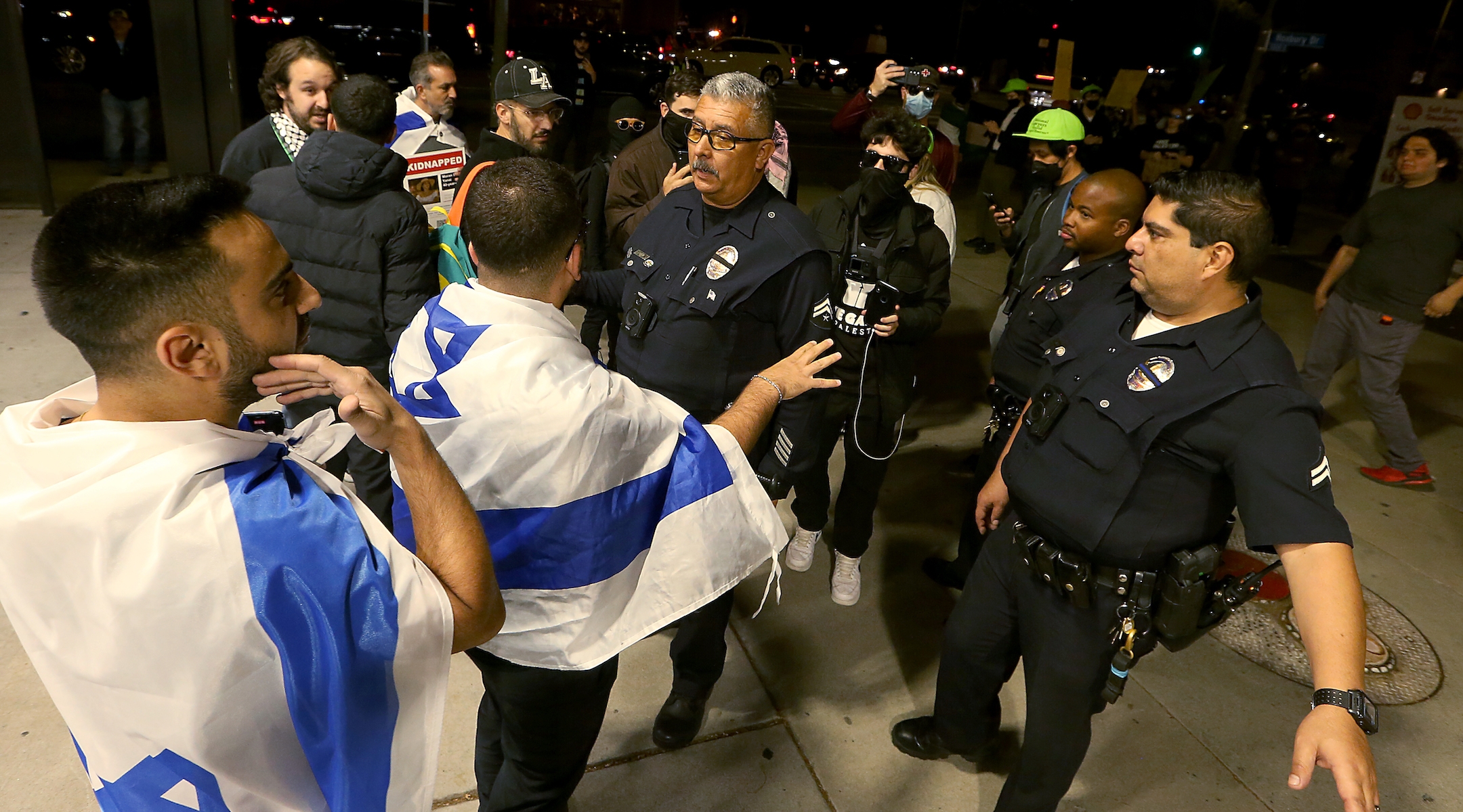 LAPD officers get between pro-Israel and pro-Palestinian activists outside The Museum of Tolerance in Los Angeles on Wednesday, Nov. 8, 2023. The museum held a private screening of footage documenting the Hamas invasion of Israel on Oct. 7th. Supporters of Palestine protested across the street outside. (Luis Sinco / Los Angeles Times via Getty Images)
