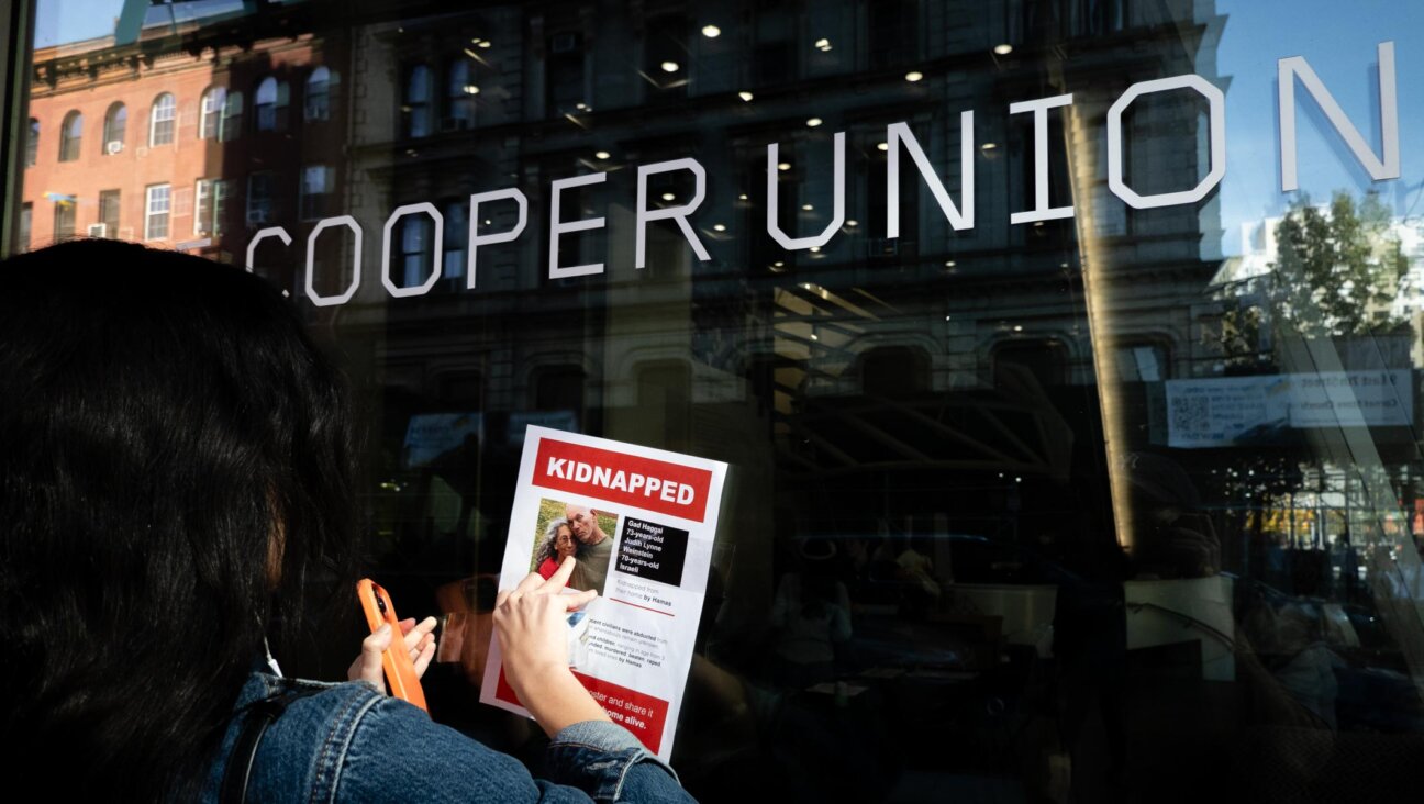 A woman affixes a flier for Israeli hostages to Cooper Union College in New York City, a day after Jewish students sheltered in a library during a pro-Palestinian protest, Oct. 26, 2023. (Luke Tress)