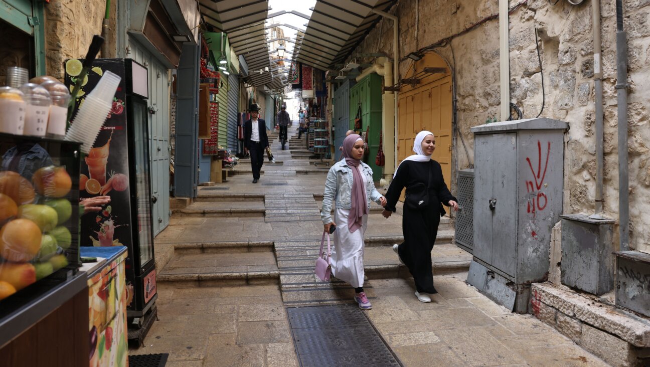 Two women in traditional Muslim garb walk through the alleys of Old Jerusalem Oct. 11. Most shops have been closed due to the ongoing war. Israeli cities have been eerily quiet and tense, with some residents noting a growing sense of fear and distrust between Jews and members of the Arab-Israeli minority.