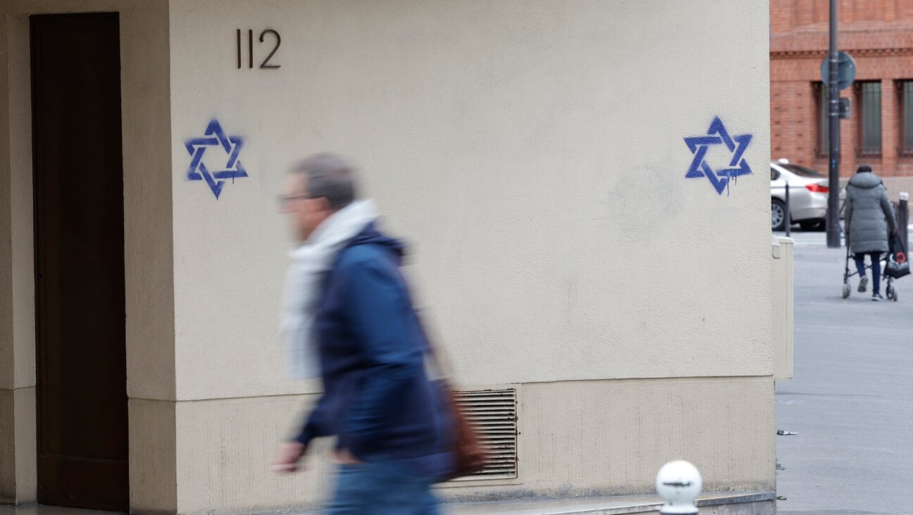 A man walks along a building whose facade is covered with Stars of David in the Alesia district of Paris, Oct. 31, 2023. (Geoffroy van der Hasselt/AFP via Getty Images)