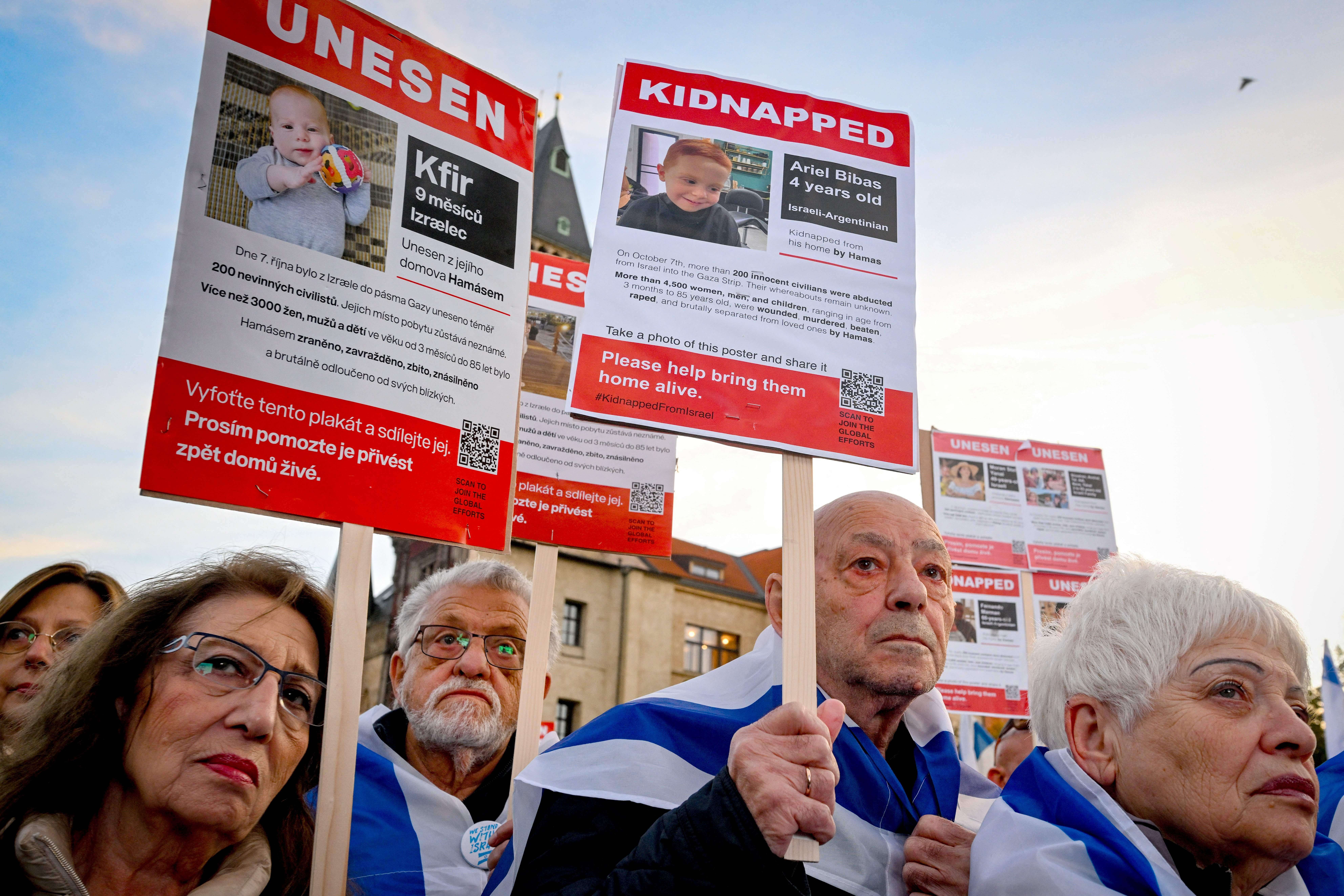 Demonstrators  in Prague hold up placards with images of Kfir (<i>left</i>) and Ariel (<i>right</i>) Bibas, young children who were kidnapped in the Oct. 7 terror attacks in southern Israel.