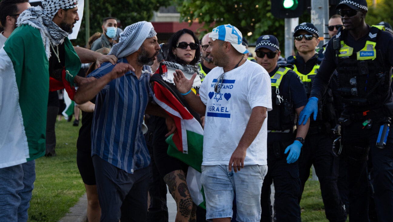 PRINCES PARK, CAUFIELD, VICTORIA, AUSTRALIA – 2023/11/10: Tense exchanges happen as a pro-Israel protester walks past the pro-Palestine demonstration. After a Burgertory chain-restaurant owned by Palestinian-Australian Hesham Tayah burned overnight in Melbourne’s most-Jewish suburb, Pro-Palestine protesters gathered in a nearby park where violent exchanges occurred with pro-Israel counter-protesters. Police deployed pepper spray on both sides and made one arrest. (Photo by Alex Zucco/SOPA Images/LightRocket via Getty Images)