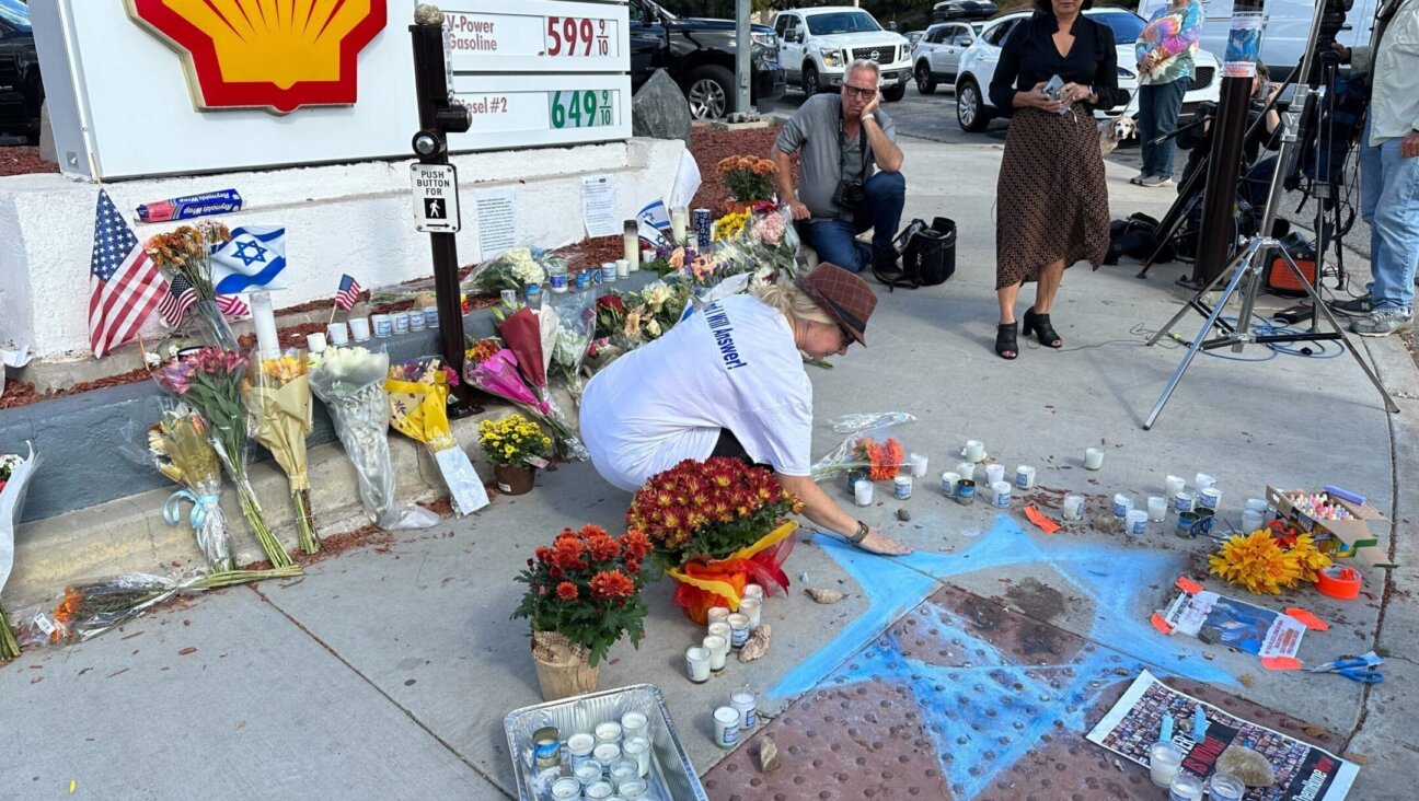 Elena Colomba draws a Star of David at a Thousand Oaks, California, street corner where a Jewish pro-Israel protester, Paul Kessler, was killed during an altercation, Nov. 7, 2023. (Jacob Gurvis)