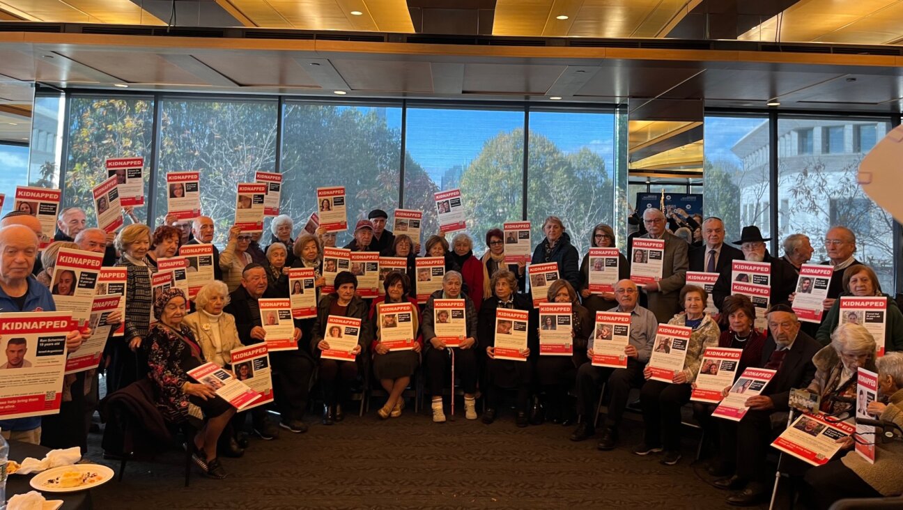 A group of Holocaust survivors pose with posters of the hostages that were kidnapped by Hamas at the Museum of Jewish Heritage: A Living Memorial to the Holocaust, Nov. 1, 2023. (Julia Gergely)