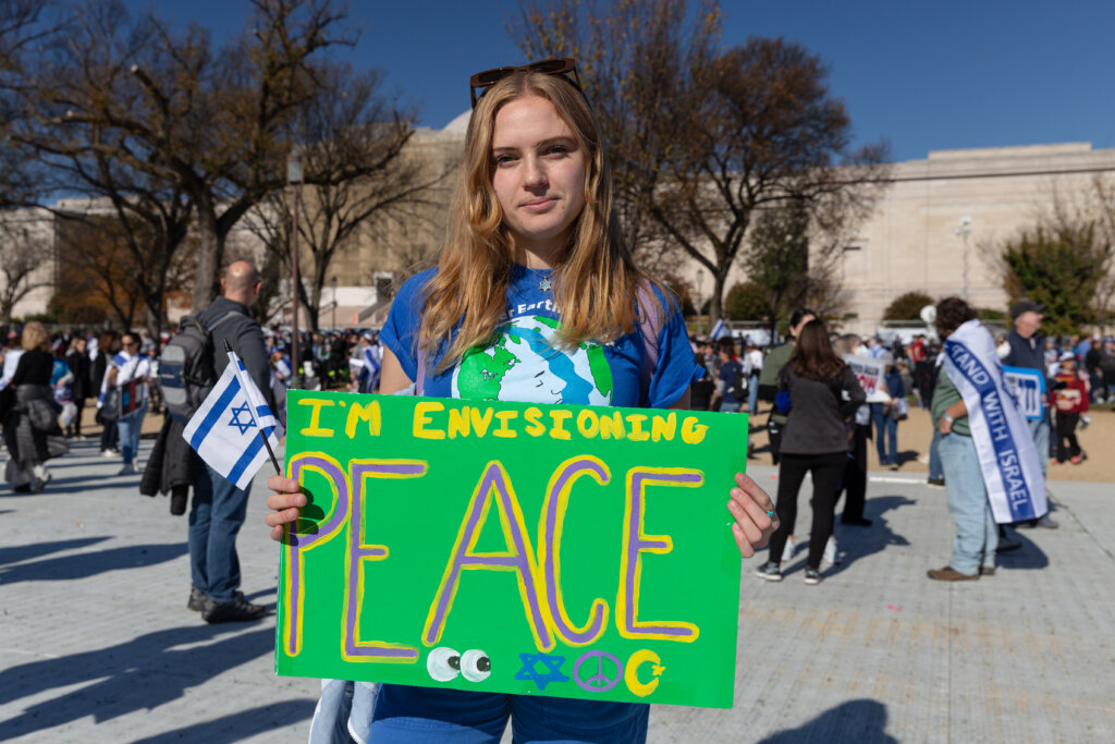 Sabrina Rubenstein, a recent Tulane University graduate, holds a green sign that says "I'm envisioning peace" at the March for Israel in Washington, D.C. on November 14, 2023.