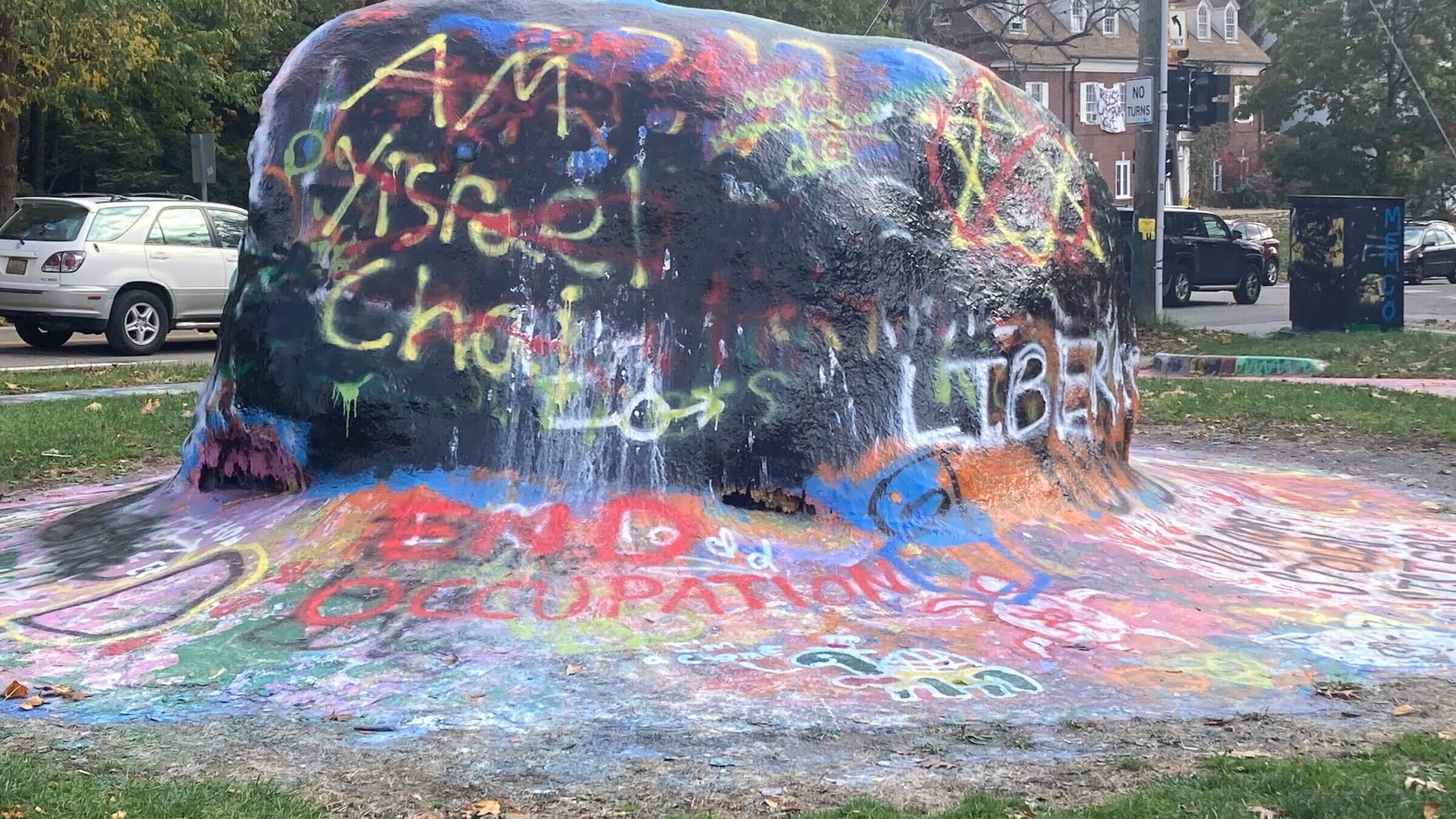 The Rock, a landmark by the University of Michigan, covered in graffiti with slogans about the war. Jewish stars and the phrase "Am Yisrael Chai" were painted over in red.