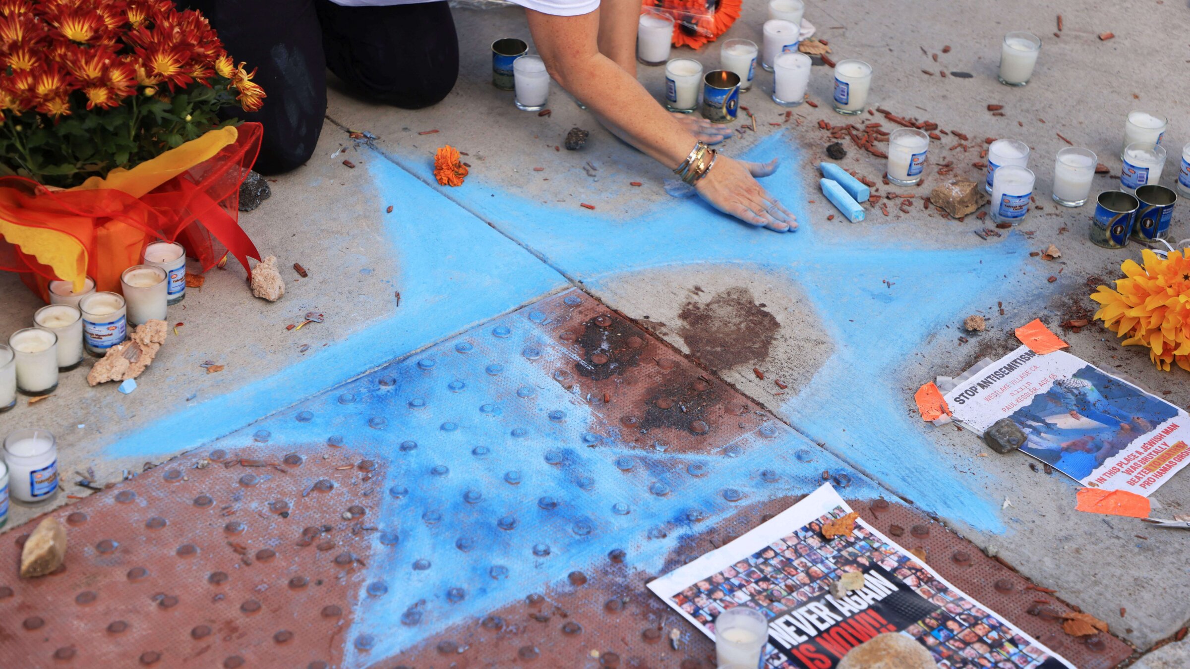 Chalk artist Elana Colombo on November 7, 2023 draws the Star of David around the blood of Paul Kessler, a Jewish man who died following an altercation during pro-Palestinian and pro-Israeli demonstrations the previous day in Thousand Oaks, California. 