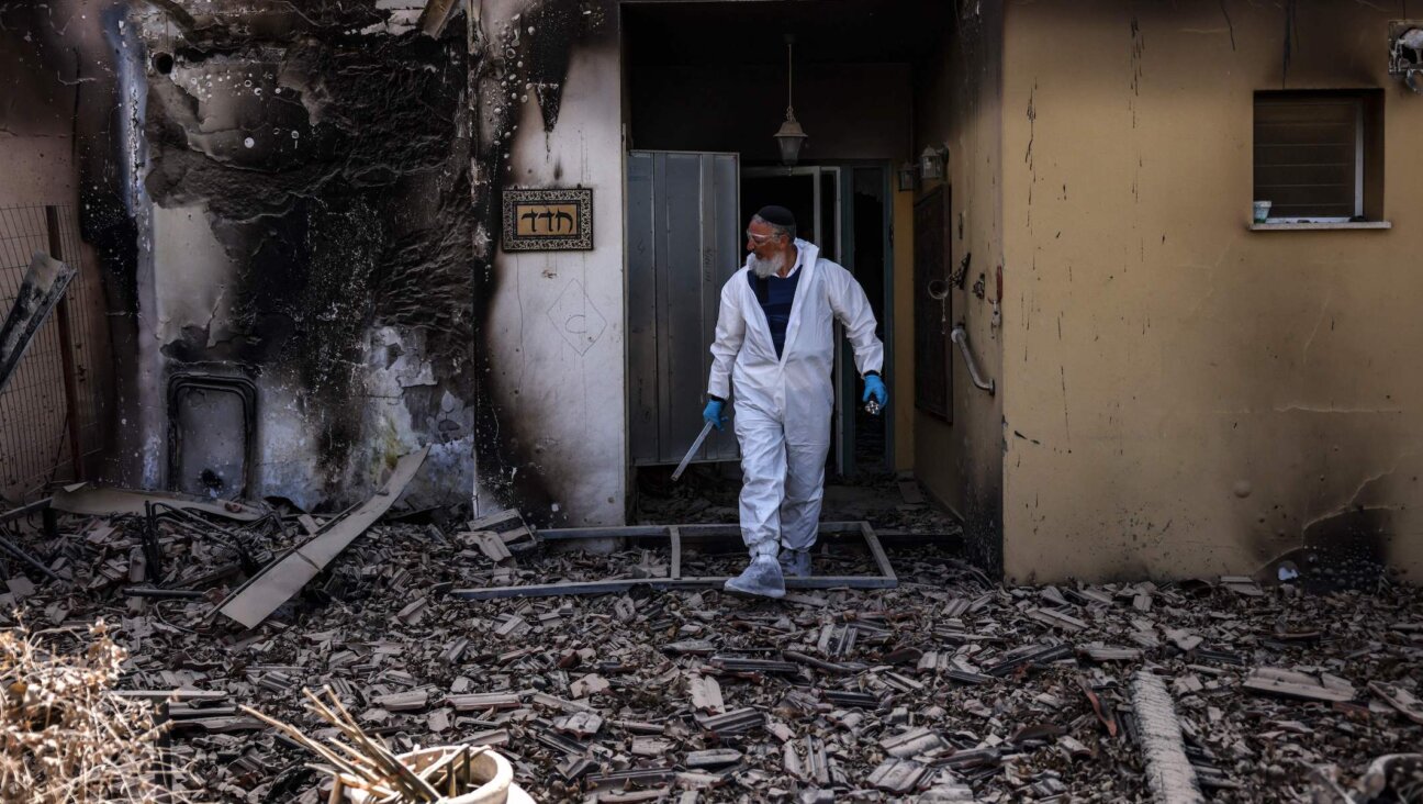 A haredi volunteer for the ZAKA emergency response service searches through the debris in Kibbutz Be’eri, near the border with Gaza, on October 20, 2023. (Ronaldo Schemidt/AFP via Getty Images)