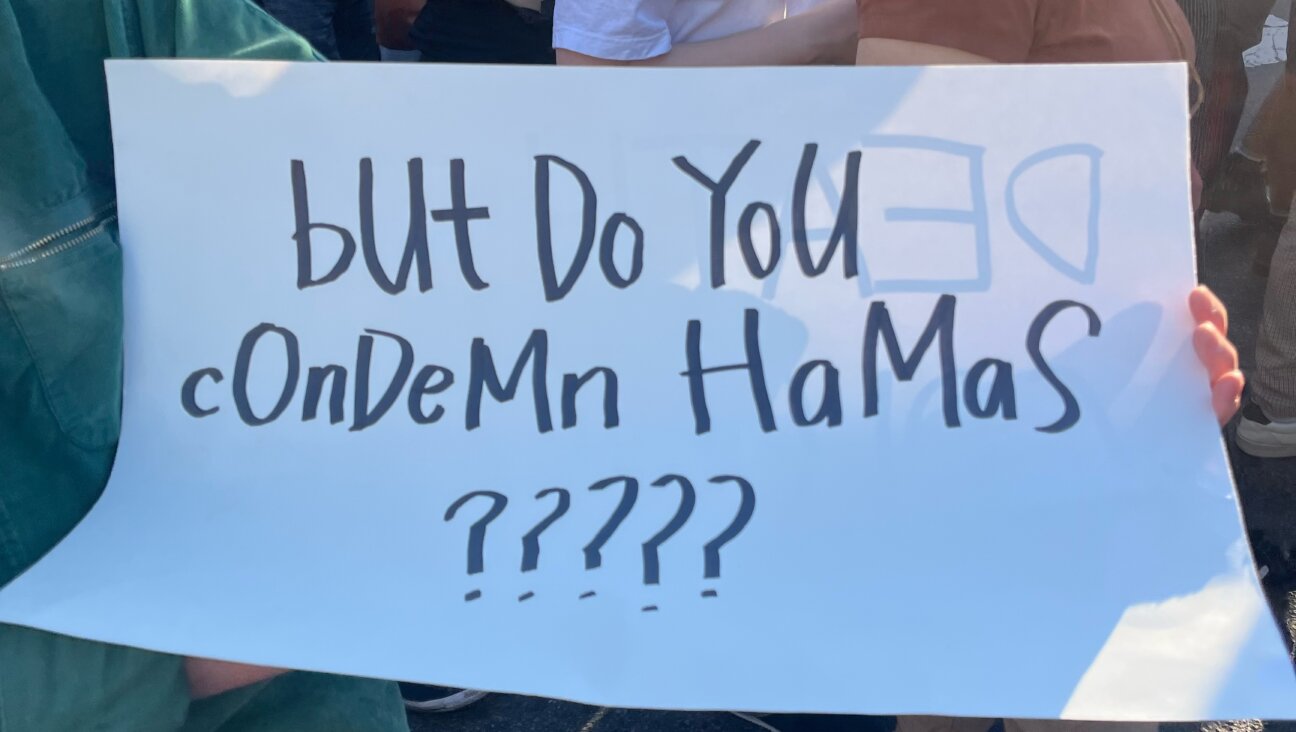At a pro-Palestine march, a woman carries a sign asking, 'But do you condemn Hamas?'