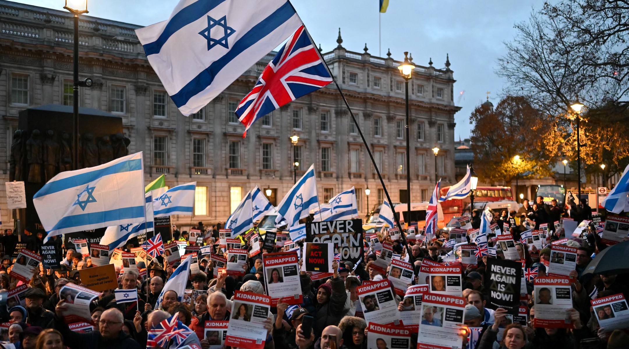 Protesters wave Israeli flags and hold photos of people held hostage by Hamas in Gaza during a demonstration outside the prime minister’s offices in London, Nov. 19, 2023. (Justin Tallis/AFP via Getty Images)