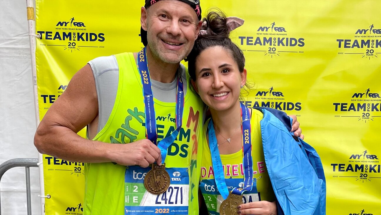 Mark Shapiro and his daughter after completing the 2022 New York City Marathon. This year, Shapiro will run wearing a T-shirt with the image of an Israeli child who was kidnapped by Hamas on Oct. 7. (Courtesy)