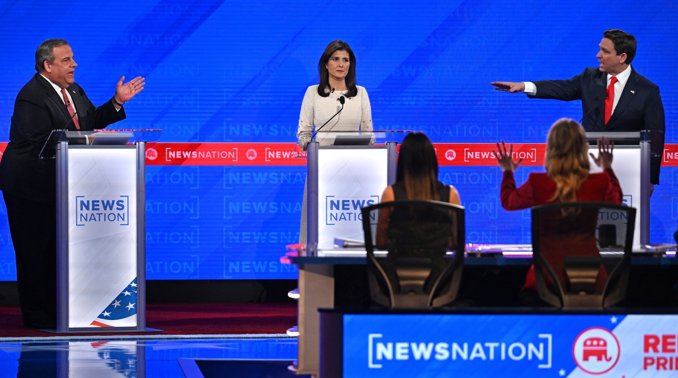 Former Governor from South Carolina Nikki Haley looks on as Florida Governor Ron DeSantis, right, and former Governor of New Jersey Chris Christie, left, gesture toward each other as they speak during the fourth Republican presidential primary debate at the University of Alabama in Tuscaloosa, Alabama, Dec. 6, 2023. Jim Watson / AFP/Getty Images)