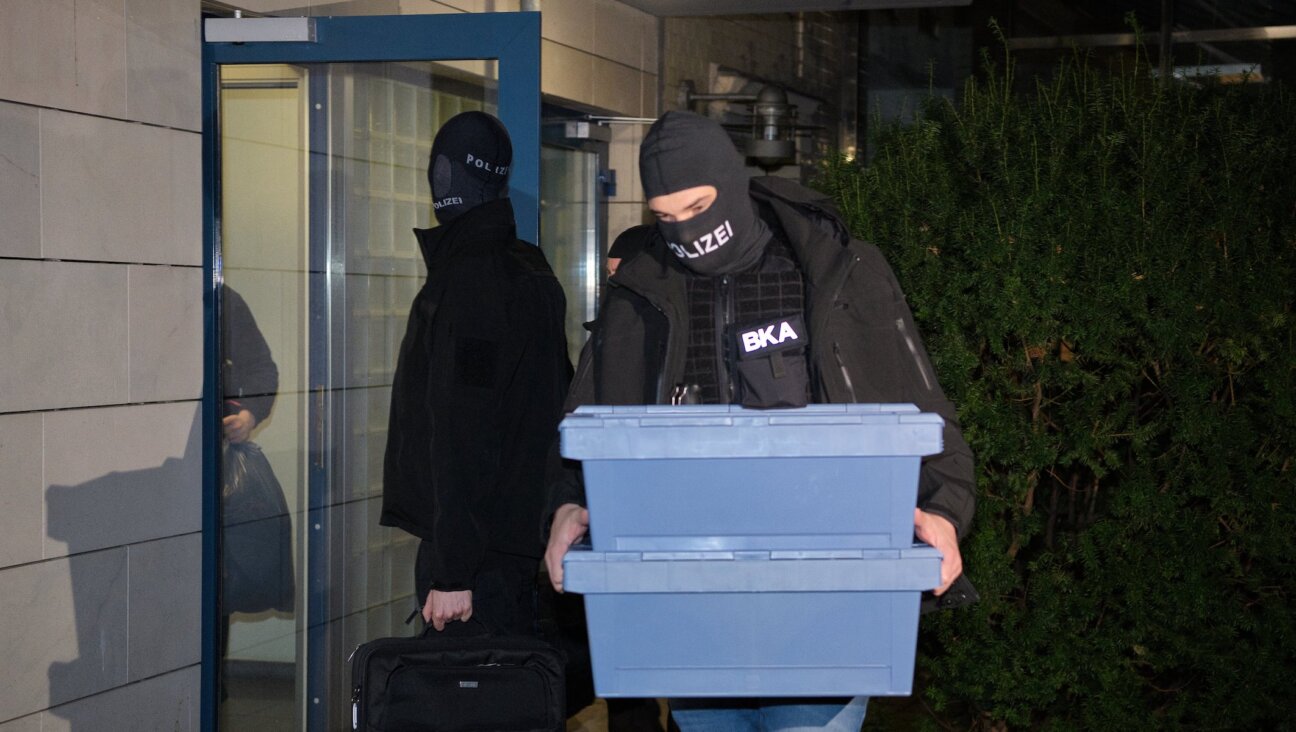 Police officers leave a house with seized evidence in Berlin, Dec. 14, 2023. (Paul Zinken/picture alliance via Getty Images)