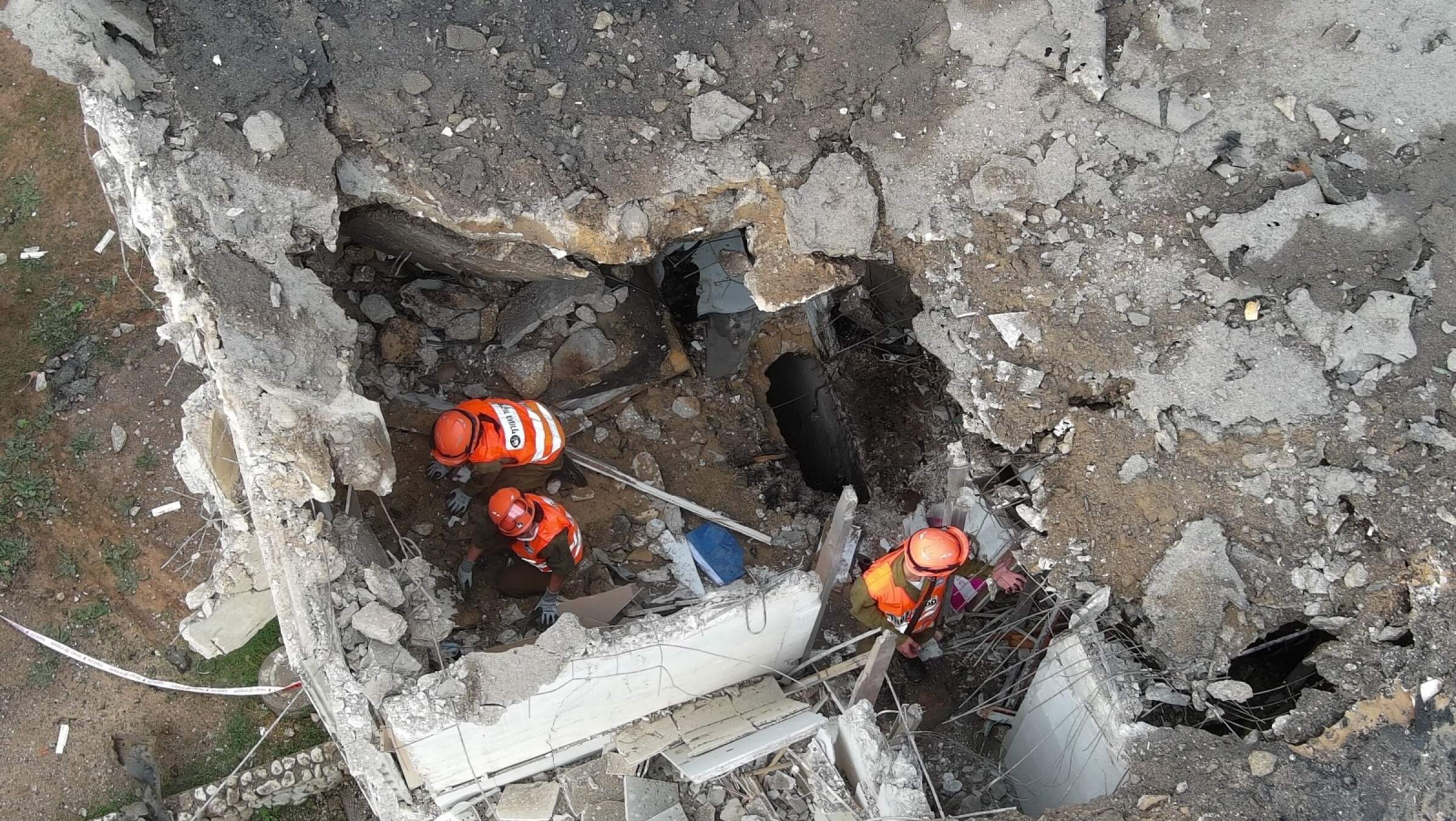 A photo taken by a member of Israel's National Drone Patrol shows first responders  assessing damage from a rocket that hit a building in a central Israeli city in October 2023.