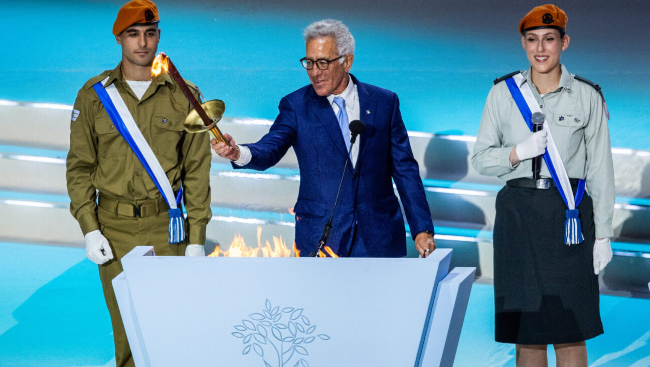 Sylvan Adams lights a torch during the reheasals for the 75th anniversary Independence Day ceremony, held at Mount Herzl, Jerusalem, April 23, 2023. (Yonatan Sindel/Flash90)
