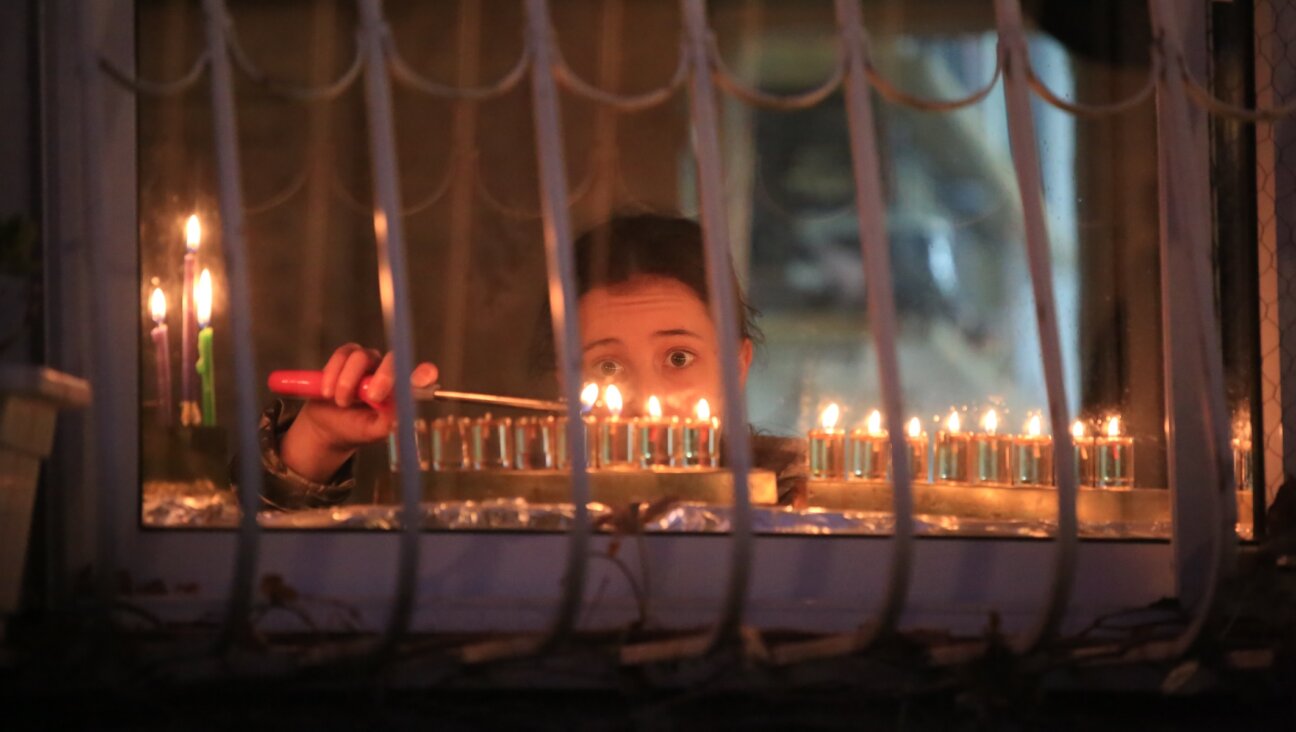 Ultra-Orthodox Jewish men light candles on the seventh night of Hanukkah in the Jewish Quarter of Jerusalem, Sunday, Dec. 25, 2022. (Saeed Qaq/NurPhoto via Getty Images)