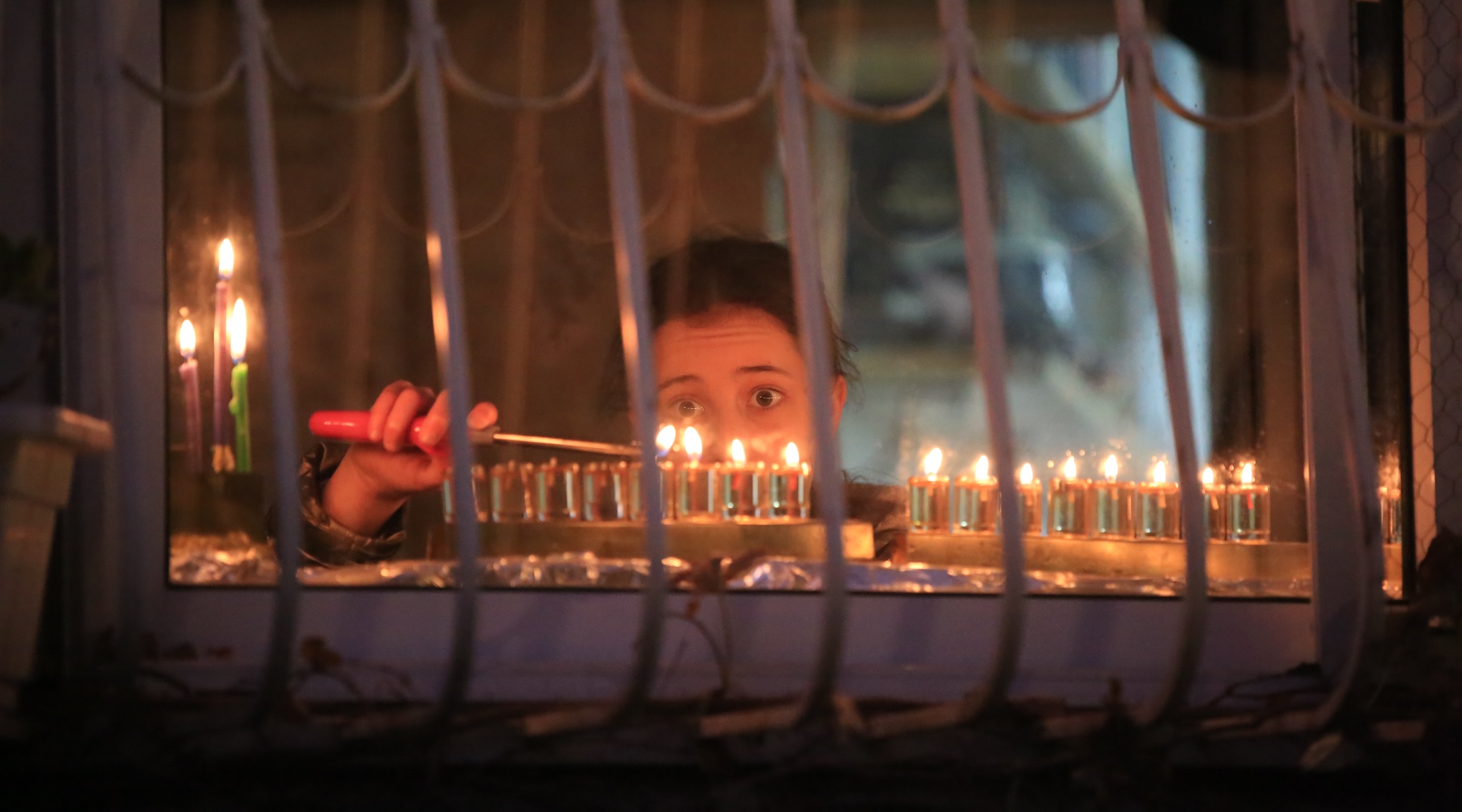 Ultra-Orthodox Jewish men light candles on the seventh night of Hanukkah in the Jewish Quarter of Jerusalem, Sunday, Dec. 25, 2022. (Saeed Qaq/NurPhoto via Getty Images)