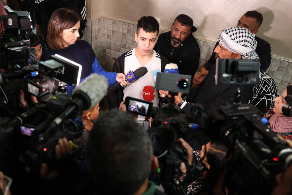 Ahmad Salaima, a 14-year-old Palestinian released under an extended truce deal,  speaks to the press with his father upon his arrival at his home in east Jerusalem on November 28, 2023.
