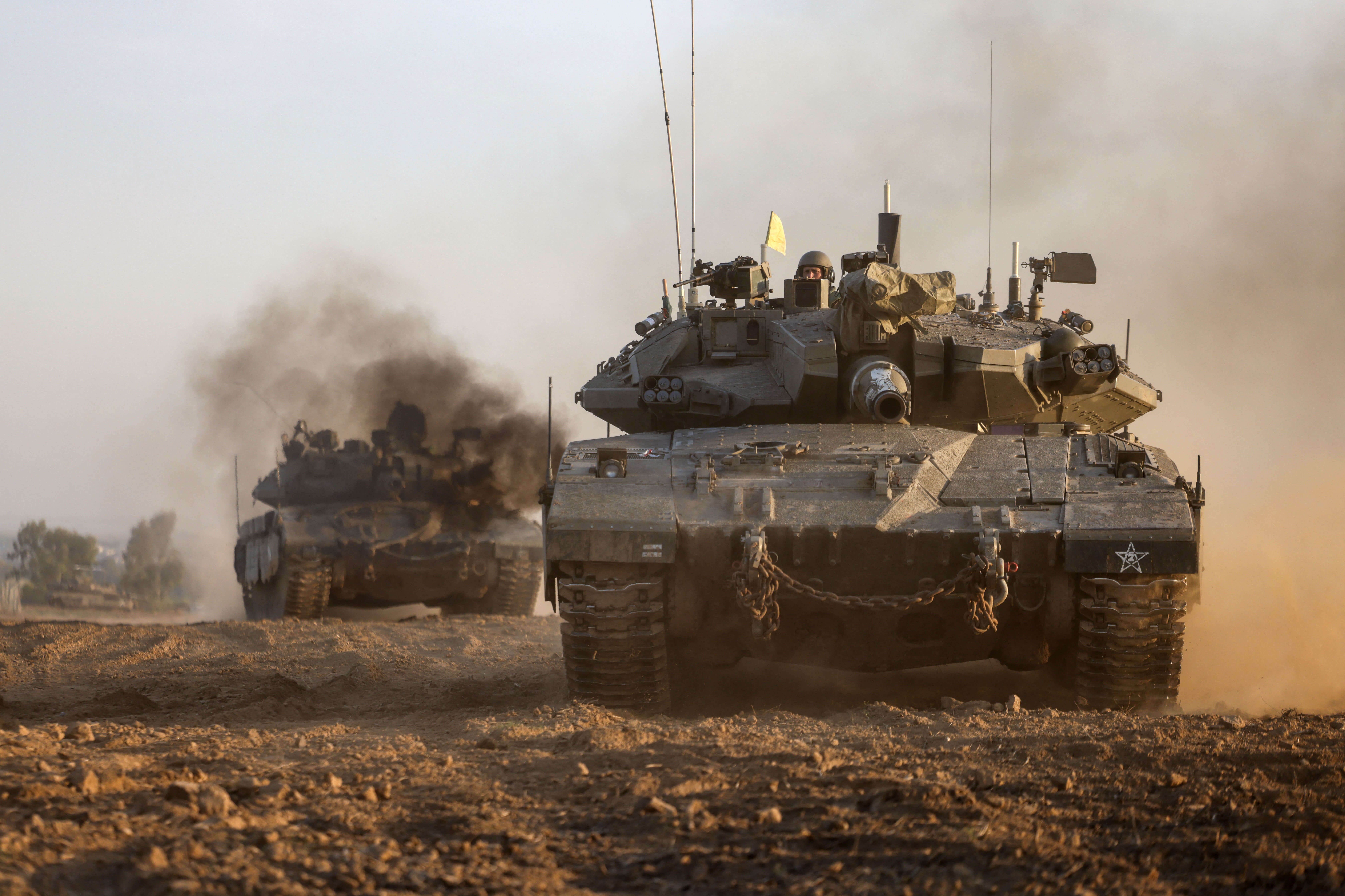  Israeli military tanks roll near the border with the Gaza Strip.