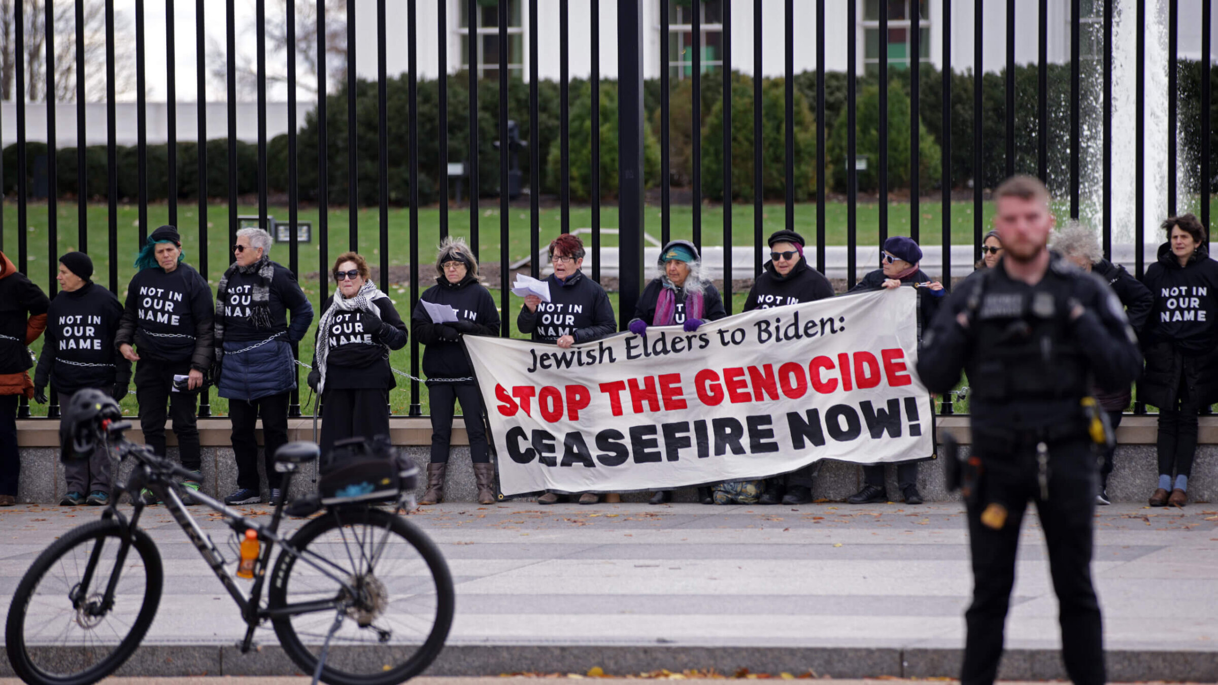 Jewish activists carrying a sign reading "Jewish Elders to Biden: Stop the Genocide, Cease-fire Now," chained themselves to the fence of the White House in December 2023.