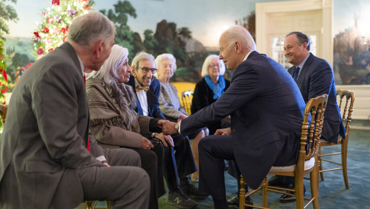 President Joe Biden greets a group of Holocaust survivors  — including Saul Dreier, wearing a bowtie — before the Hanukkah reception on Dec. 11. 