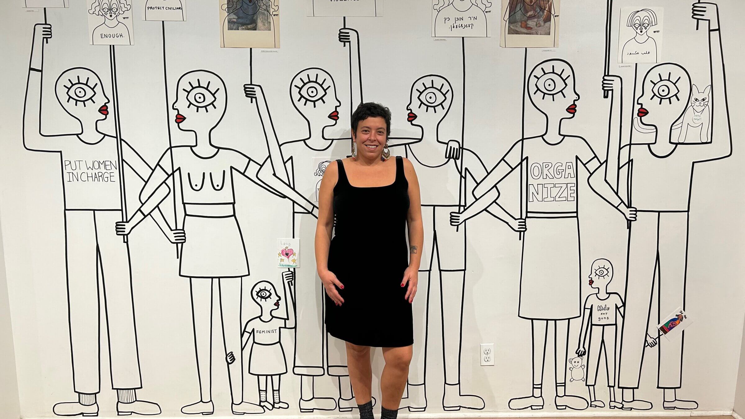Sara Erenthal poses in front of one of her murals at her new exhibition at the Brooklyn Artery.