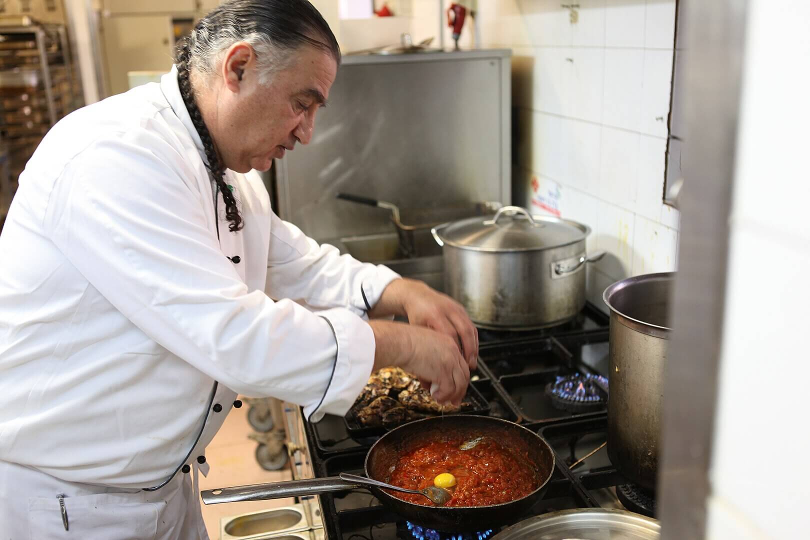 Chef Moshe Basson preparing shakshuka at his Eucalyptus restaurant in Jerusalem.
