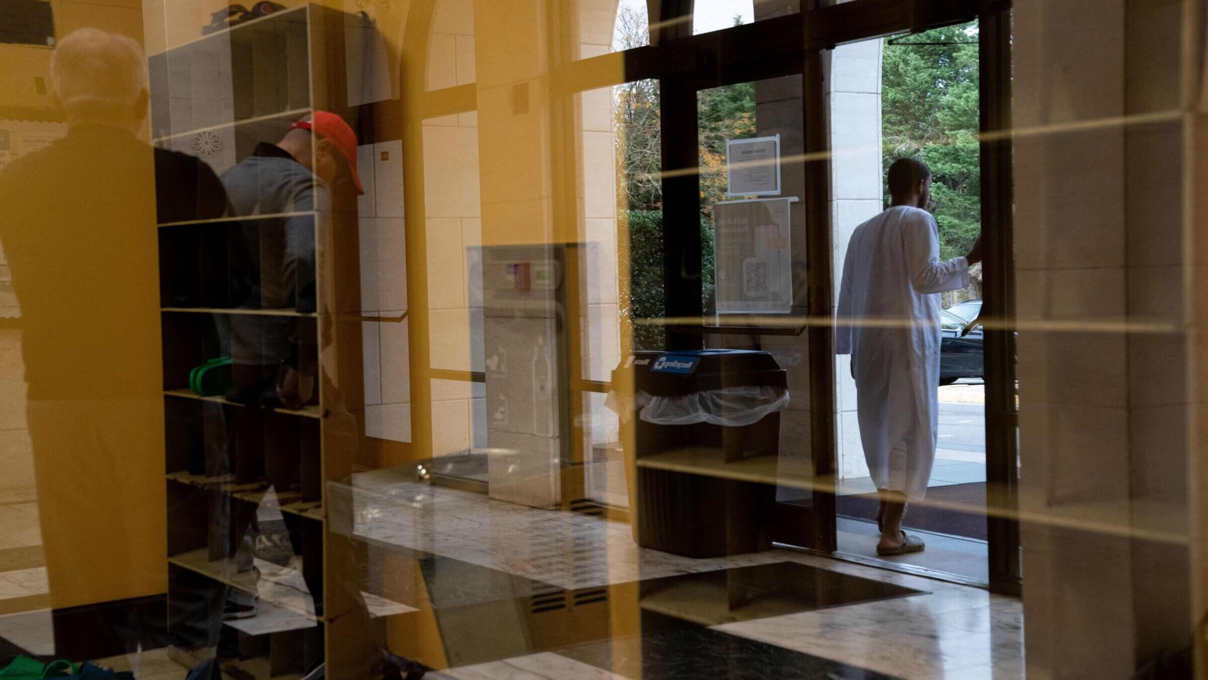 Shoes removed for prayer with congregants reflected in glass as they depart Dar Al Hijrah Islamic Center in Falls Church, Virginia, in October. The Council on American Islamic Relations Reported a surge in discrimination reports it has received since October.