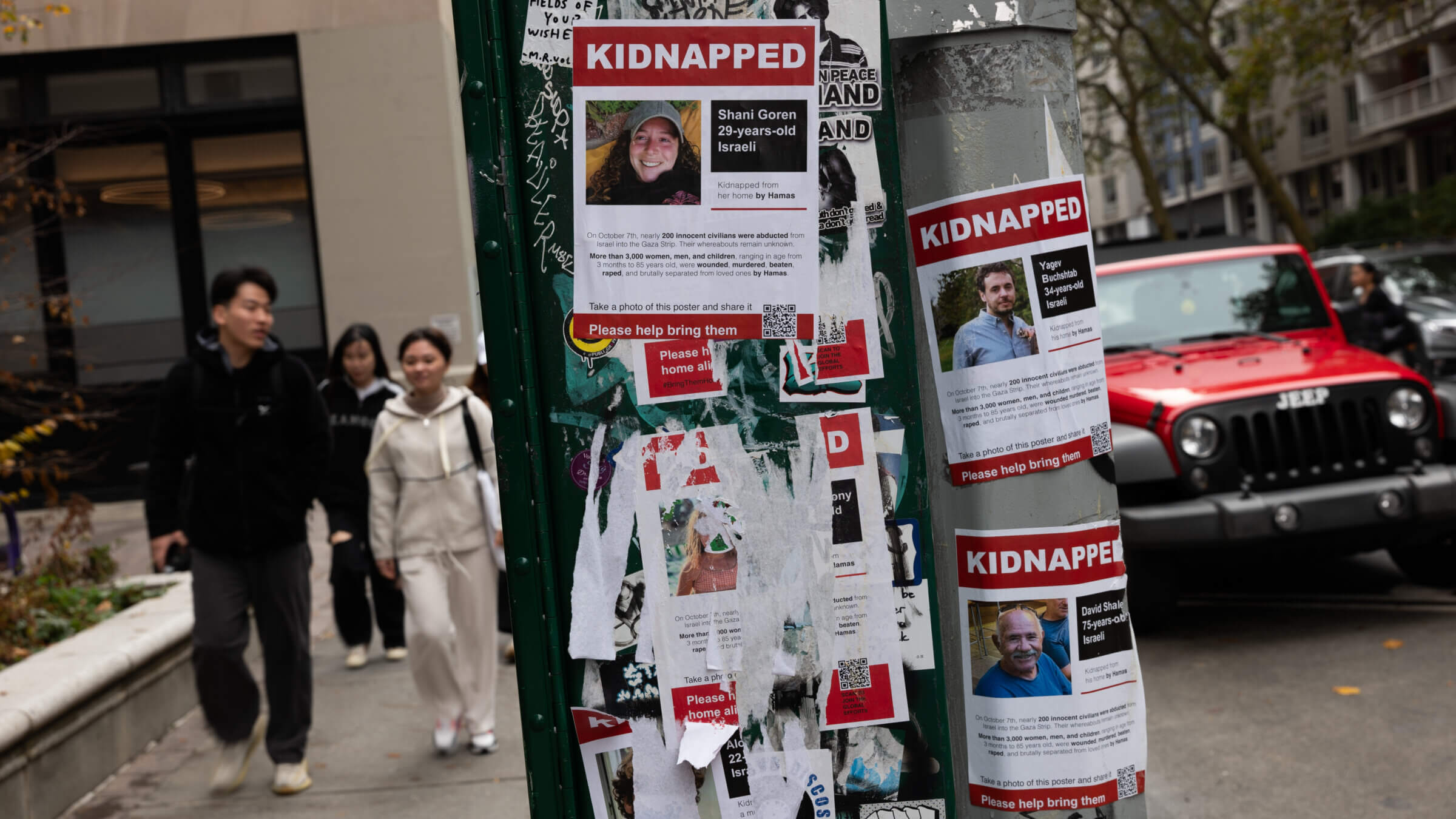 Posters of people kidnapped by Hamas in Israeli are displayed on a pole outside of New York University. New rules at some colleges would prohibit posting such posters directly on school property.